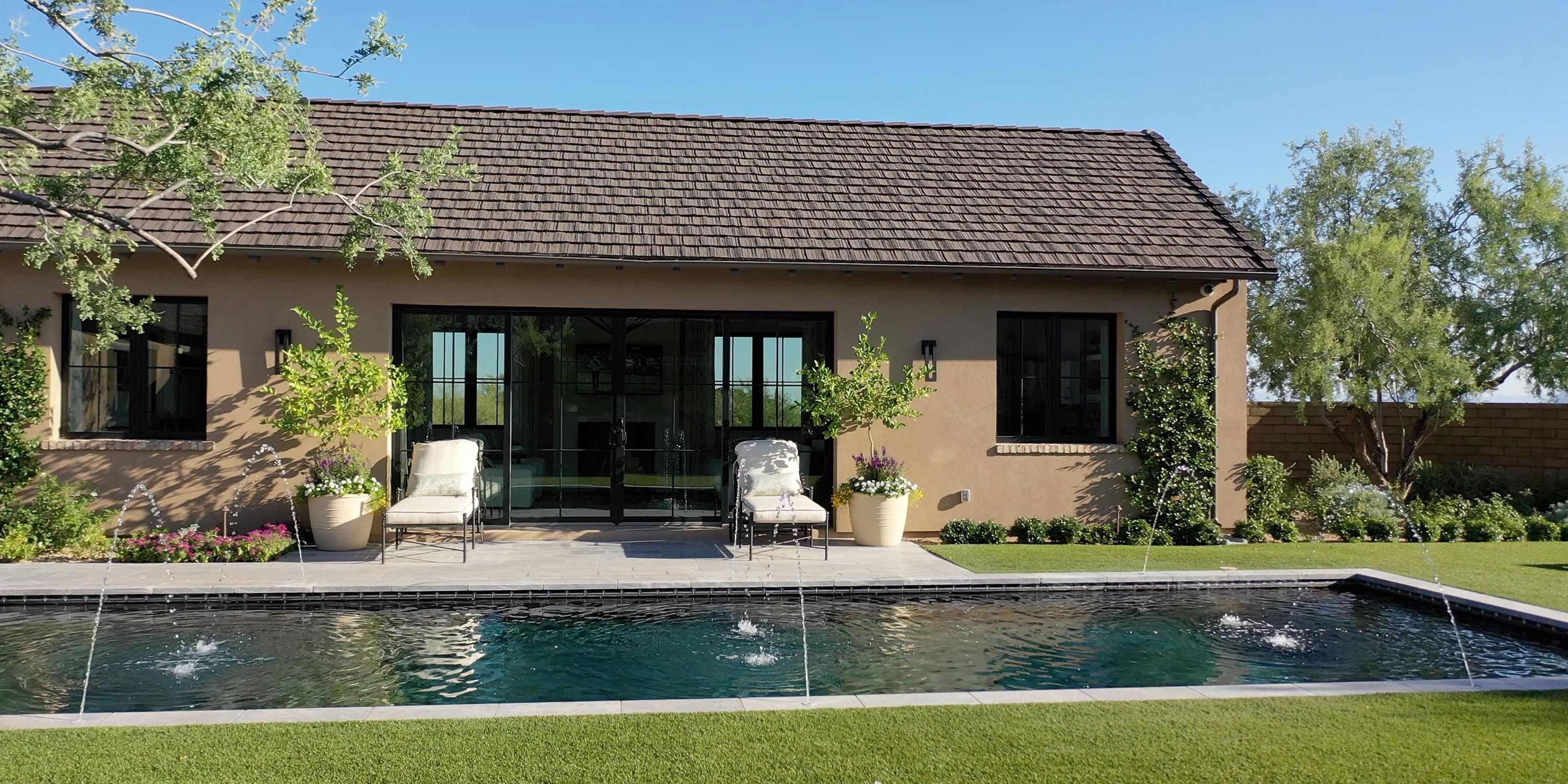 Beautiful backyard with a swimming pool, lounge chairs, and vibrant garden.