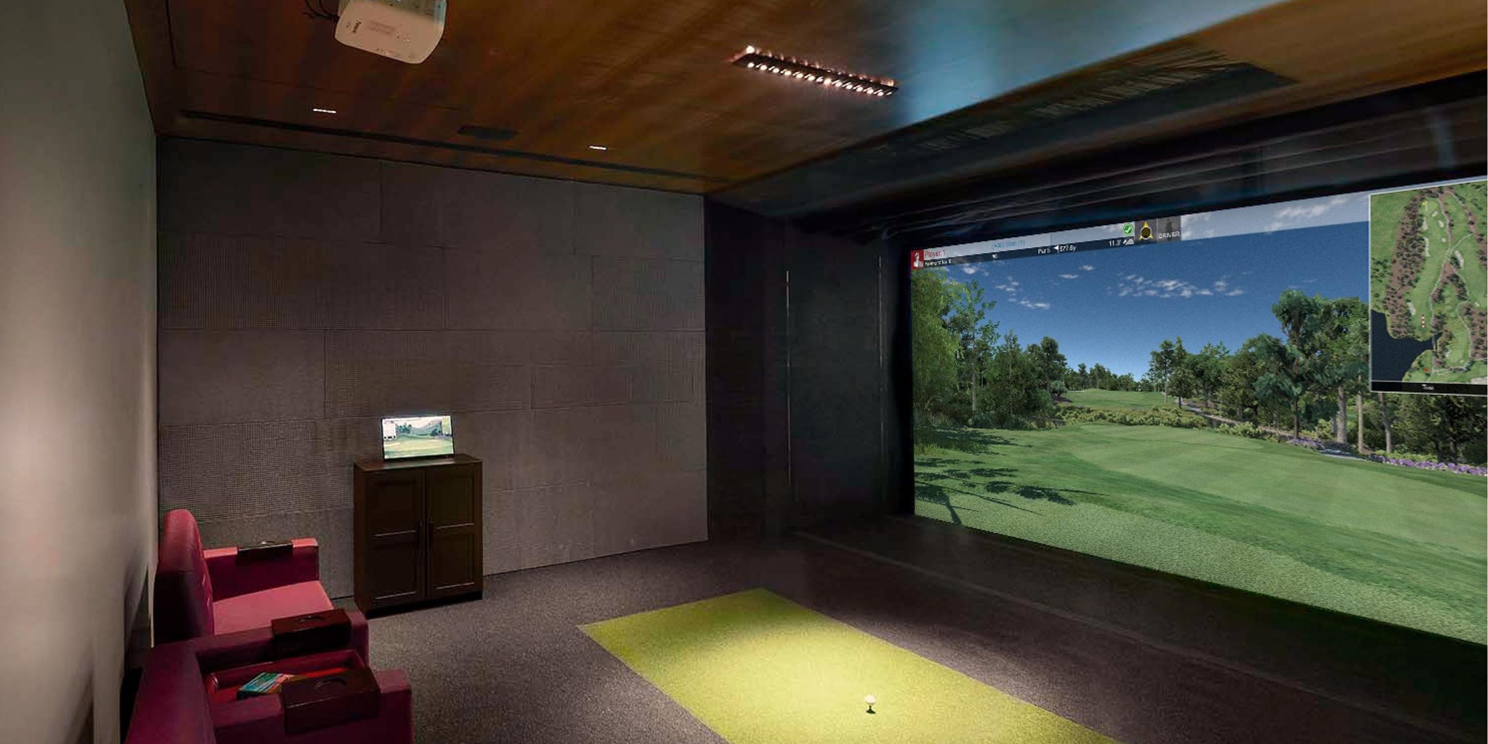 Indoor golf simulator setup with a large screen, golf clubs, and a putting green area.