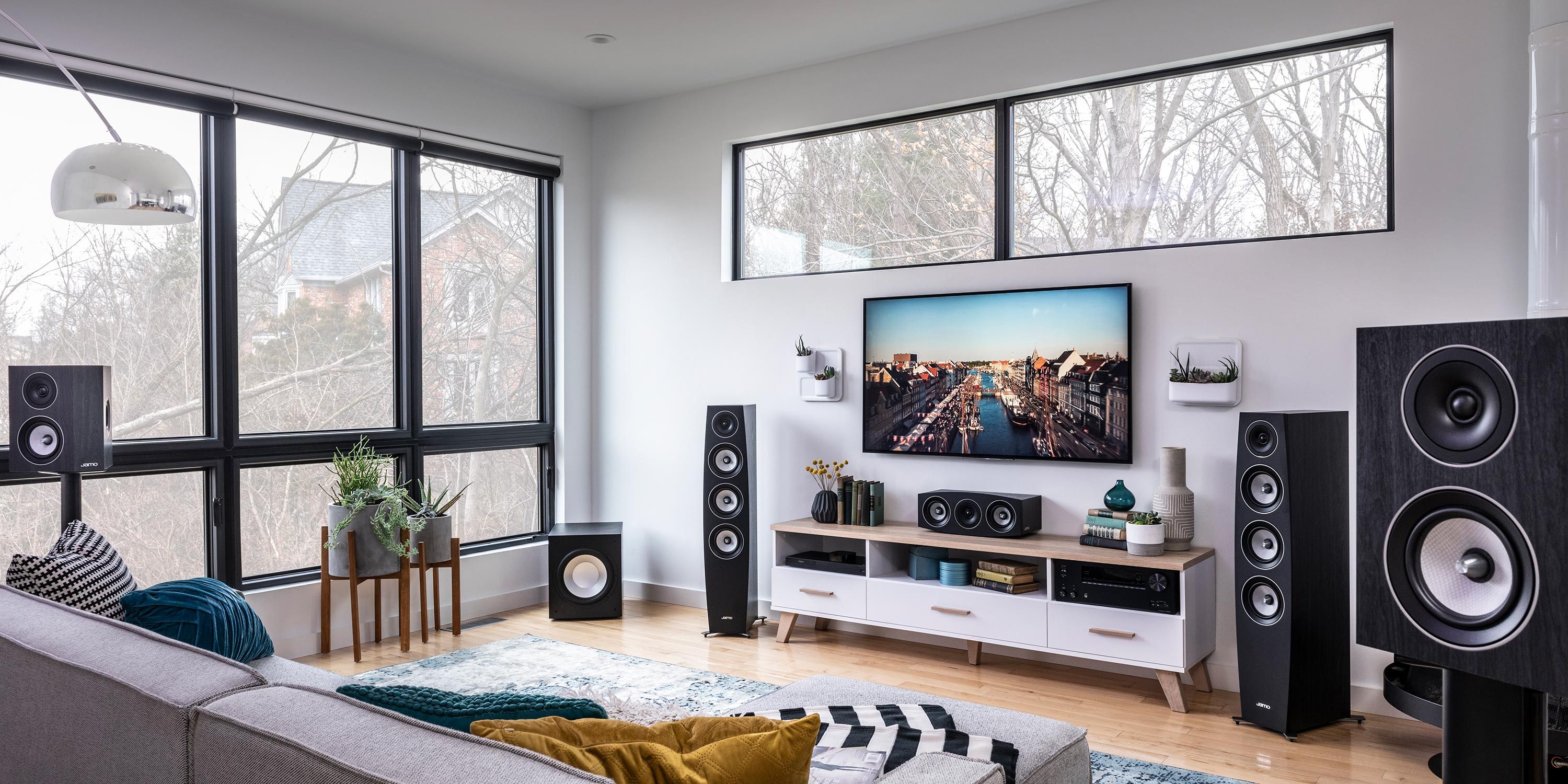 Stylish media room with a large TV, surround sound speakers, and a comfortable sectional sofa.