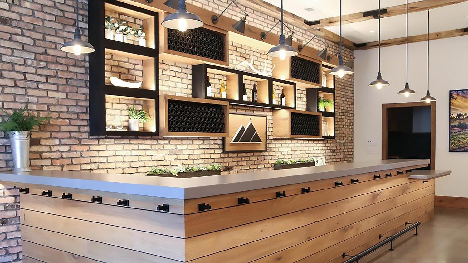 Stylish bar area with exposed brick walls, custom shelving, and pendant lighting creating a warm ambiance.